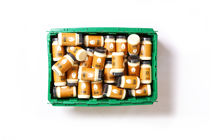 A green MakeSpace storage bin full of jars of Hampton Creek Just Mayo, a gluten-free, egg-free, soy-free , and canola oil mayonnaise substitute.