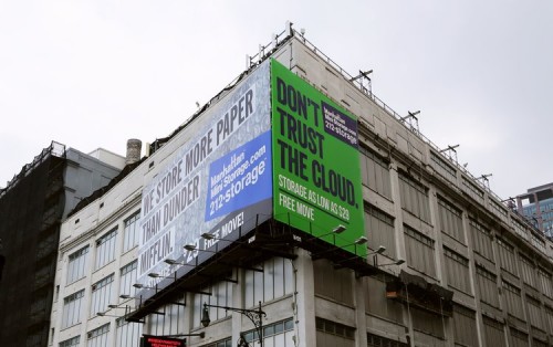 2 Manhattan Mini Storage billboards in NYC: "We store more paper than dunder mifflin." and "Don't trust the cloud."