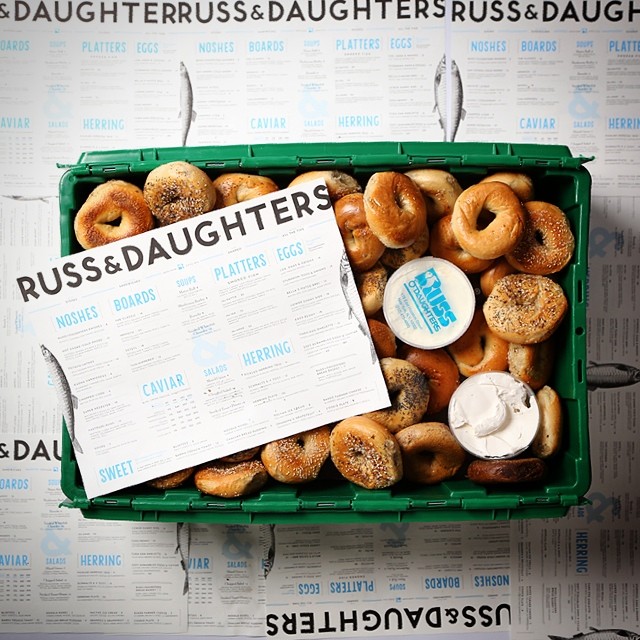 A green MakeSpace storage bin is full of assorted Russ & Daughter's bagels.