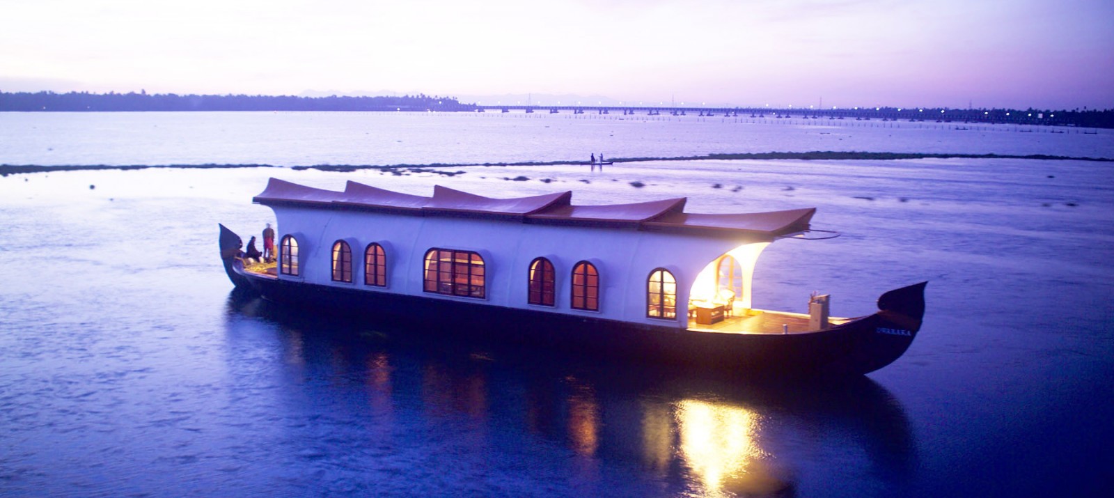 A small houseboat with clever storage and space-saving solutions is sailing in water.