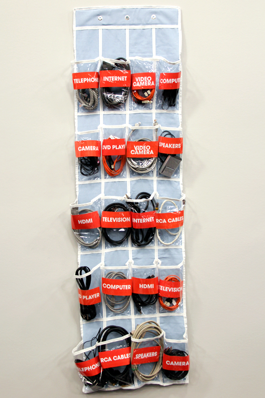 an over-the-door shoe organizer repurposed to store various cables, cords, and wires
