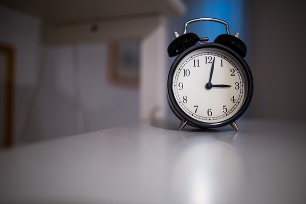 black alarm clock that reads 3:02 am