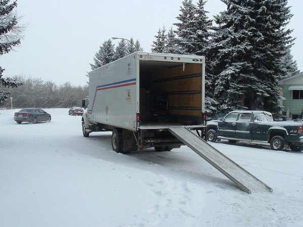 moving truck with a ramp extended onto the snow