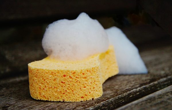 soapy yellow sponge on a wood floor