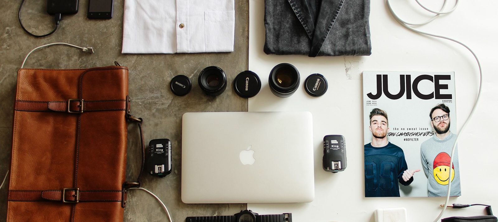 organizing your stuff: leather bag, macbook, watch, shirts, shoes, a magazine, photography accessories, cords, pencils, and a pen