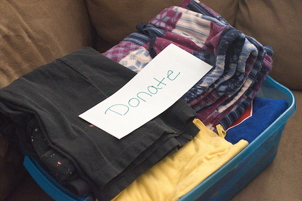 a pile of clothes await in a donation box
