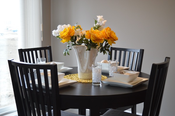 fresh white and yellow flowers in a white vase on a kitchen table