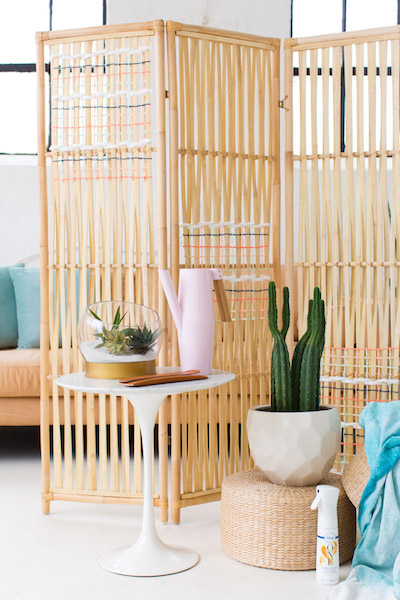 a bright rattan-woven folding screen divides a room in two