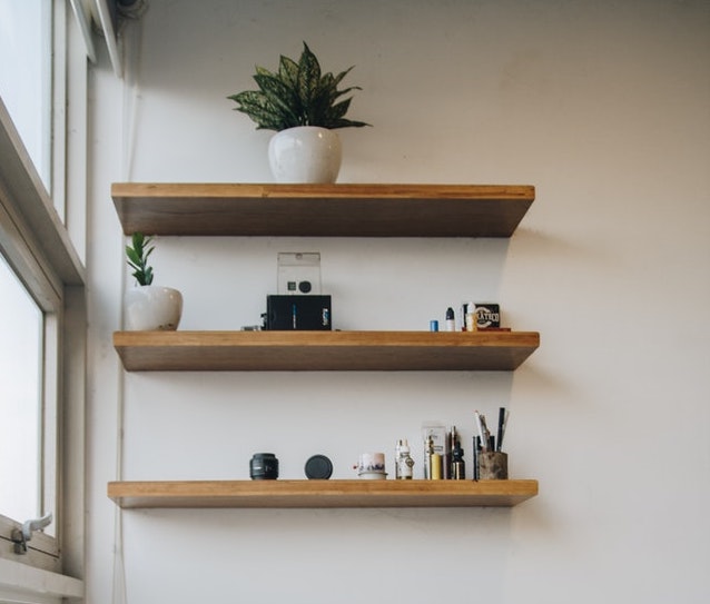 a shelf with plants and stationery 