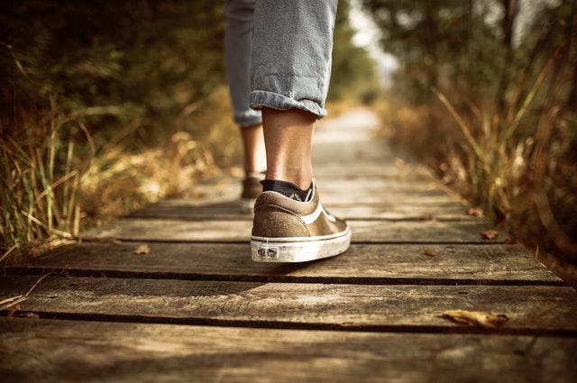a person on a pavement, going for a walk