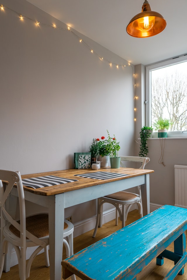 A dinning table for two with string lights and a cozy lamp