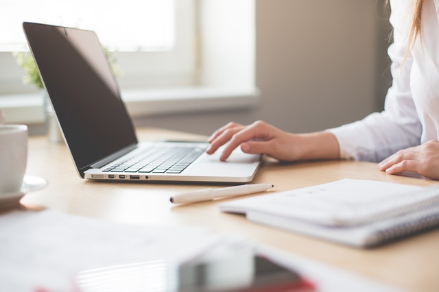A hand scrolling on a clean laptop