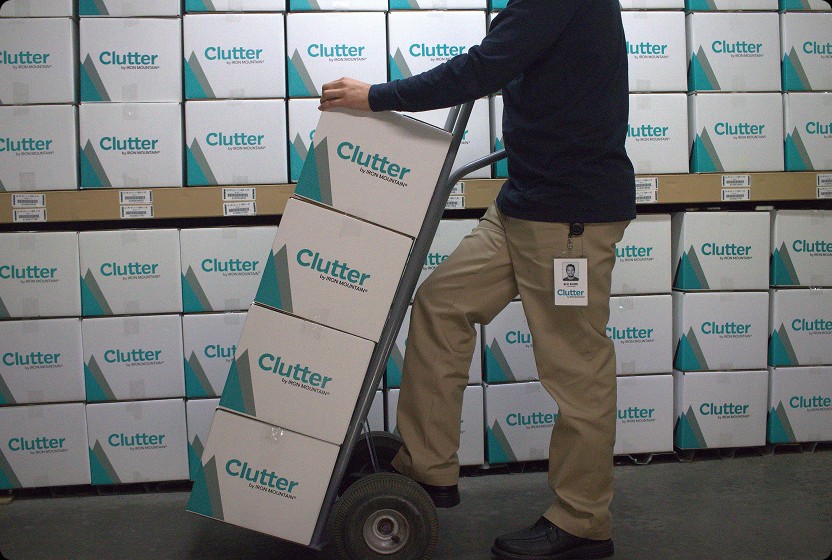 Clutter team member moving Clutter by Iron Mountain boxes with a hand truck