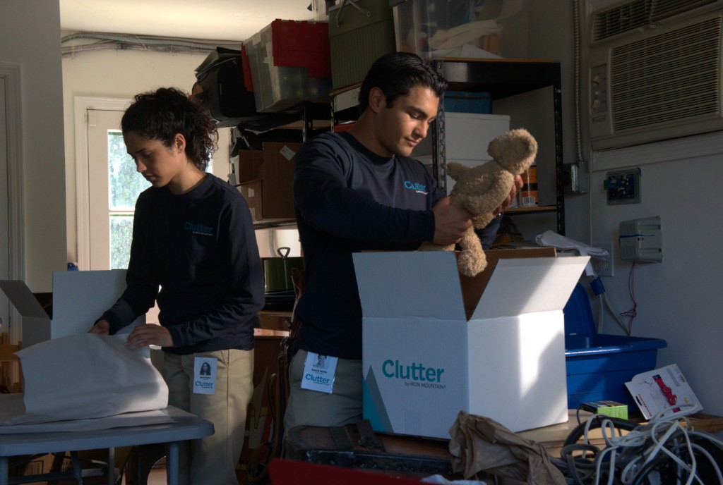 Clutter team packing items into branded boxes